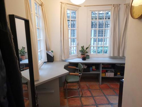 巴黎Charmant studio atypique的客房设有书桌和2扇窗户。