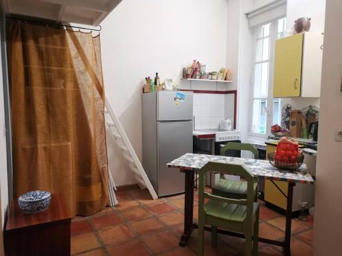 巴黎Charmant studio atypique的厨房配有桌子和冰箱