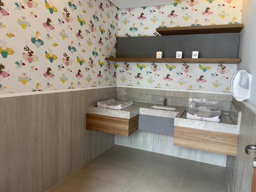 圣代佩德罗São Pedro Thermas Resort的一间带水槽的浴室和鸟语壁纸