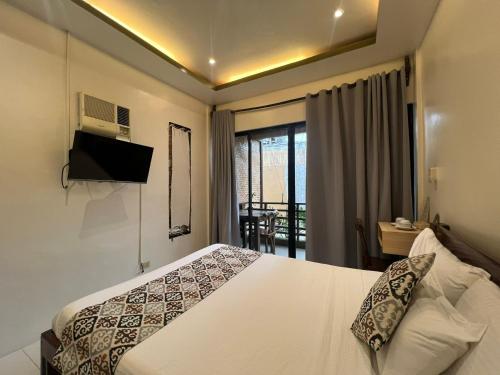 爱妮岛Bulul Garden Resort的酒店客房设有一张床和一个阳台。
