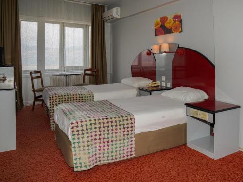 班德尔马HOTEL EKEN的酒店客房设有两张床和一张桌子。