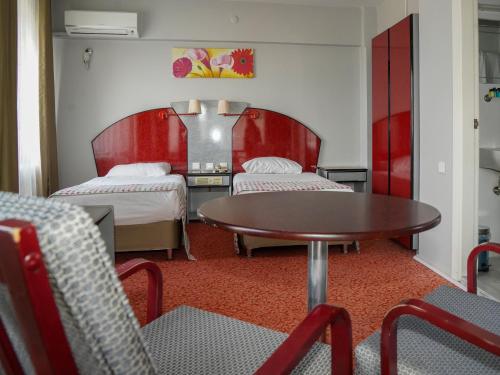 班德尔马HOTEL EKEN的一间设有两张床和一张桌子及椅子的房间