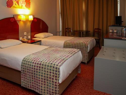 班德尔马HOTEL EKEN的酒店客房设有两张床和一张桌子。