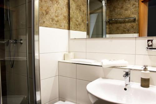 BerggiesshübelHotel Sächsisches Haus的白色的浴室设有水槽和淋浴。
