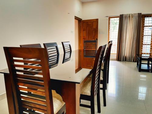 德里久尔Thrissur Villas Home Stay的一间带桌椅的用餐室