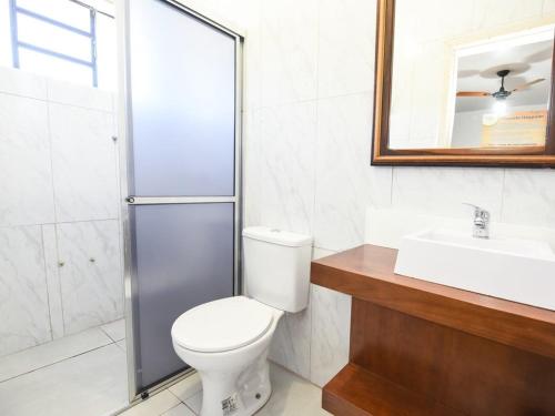 卡内拉Hotel Pequenino的浴室配有卫生间、盥洗盆和淋浴。