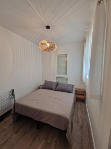 阿格德角T2 Cap d'agde centre port的一间带一张床和吊灯的小卧室