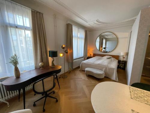 苏黎世Exclusive one room apartment next to Zürich main station的一间卧室配有一张床、一张书桌和一面镜子