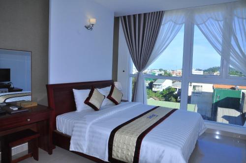 广义坎坦酒店的一间卧室设有一张床和一个大窗户