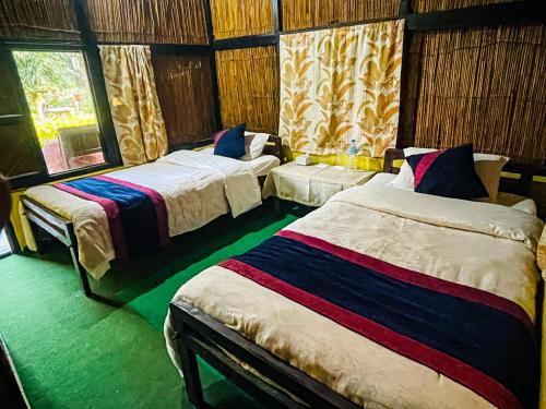 奇旺Hotel Tharu Garden And Beer Bar的一间卧室设有两张床和窗户。