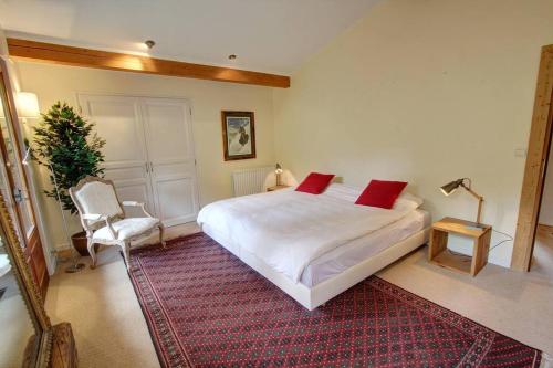 夏蒙尼-勃朗峰Chalet Clara的卧室配有一张白色大床和一把椅子