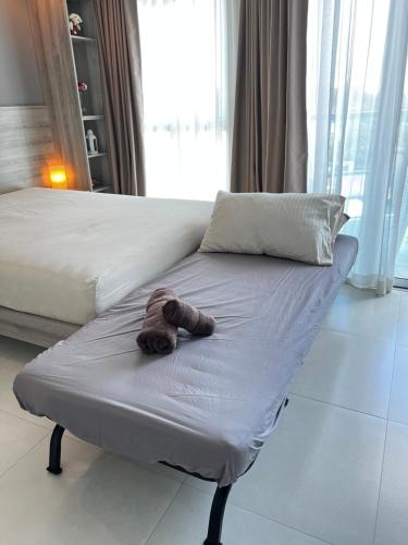 梅尔皮姆Grandblue Condominium#702 Seaview TopFloor MaePim Rayong的躺在床上的泰迪熊