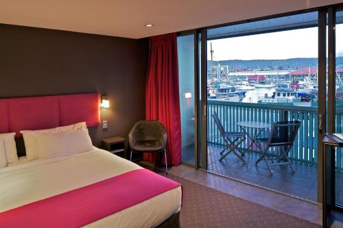 霍巴特泽罗戴维精品公寓酒店的酒店客房设有一张床和一个美景阳台