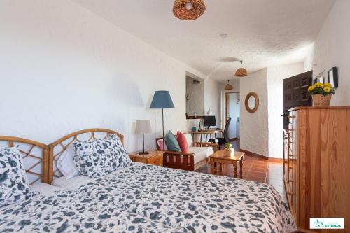 阿尔特纳拉Living Artenara - EARTH Adults Only的一间卧室设有一张床和一间客厅。