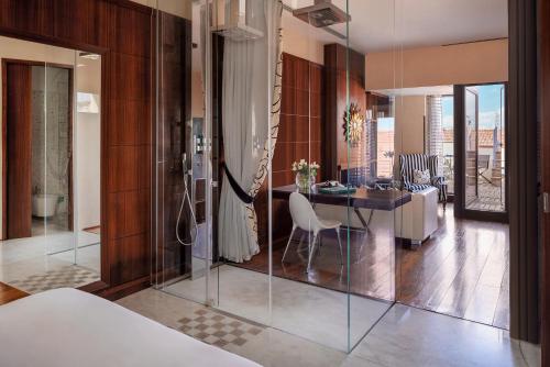佛罗伦萨Repubblica Firenze Luxury Apartments | UNA Esperienze的一间卧室,带一张桌子的房间和一间餐厅