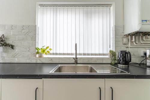 利物浦Modern 4bedroom Spacious Family Home的厨房设有水槽和窗户。