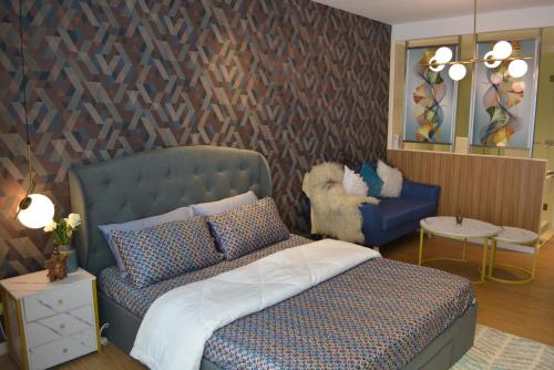 马尼拉Luxxe interior design condo @ Novotel Suites Manila - Acqua的一间卧室配有一张床、一张沙发和一把椅子