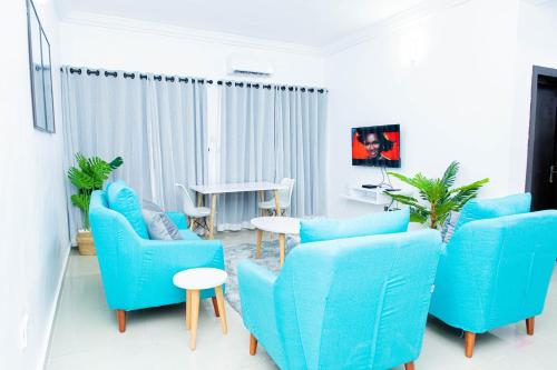 莱基Novara Apartments的客厅配有蓝色的椅子和桌子