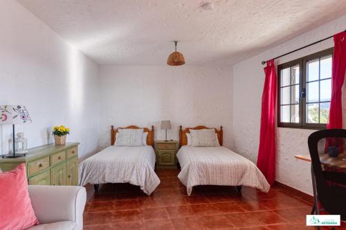 阿尔特纳拉Living Artenara - NATURE Adults Only的配有红色窗帘的客房内的两张床