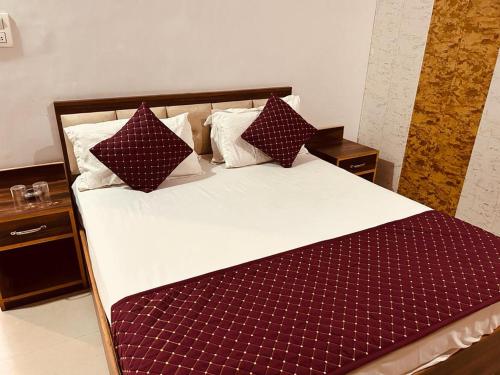 瑞诗凯诗4 U Premium Tapovan Rishikesh的一张大床,配有红色和白色的床单和枕头