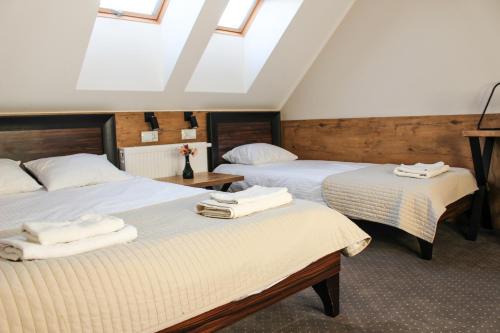 拉多姆Hotel Regina的一间卧室配有两张床和白色毛巾。