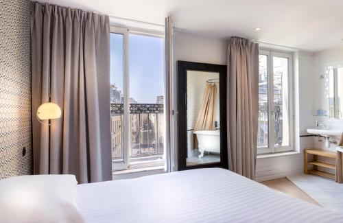 巴黎Hôtel Emile Le Marais的一间卧室配有一张床,享有一间浴室的景色