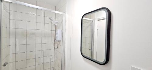 卡迪夫Harlequin Apartments by Switchback Stays的浴室墙上挂着镜子