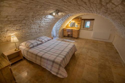 FarguesMaisonnette Lotoise, meublé de tourisme 3 étoiles的卧室配有一张石墙床