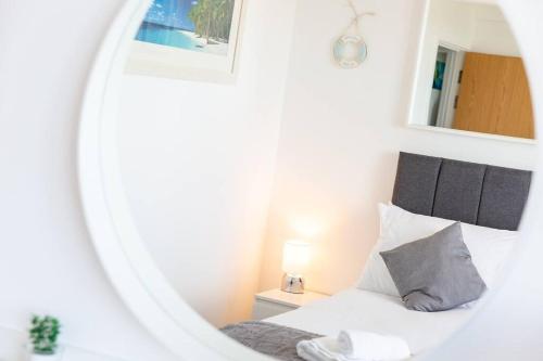 纽基Newquay Sunset & Sea View Apartment in Town Centre的卧室配有白色的床和镜子