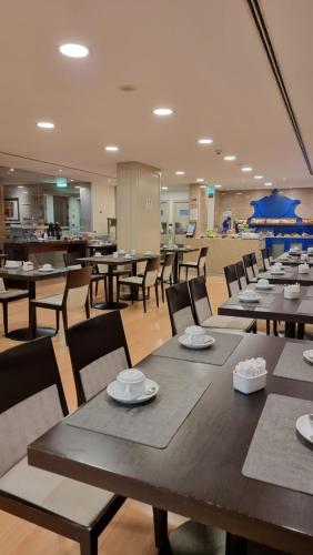里斯本普林西比里斯本酒店的自助餐厅内带桌椅的用餐室
