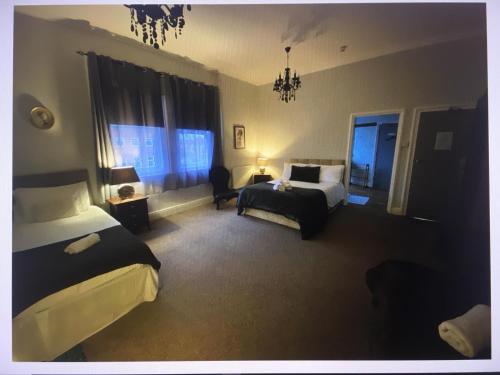 普雷斯顿St Andrews house Hotel的酒店客房,设有两张床、一张床和椅子