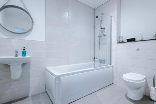 威根Victoria Mill by Staycay的白色的浴室设有浴缸、卫生间和水槽。