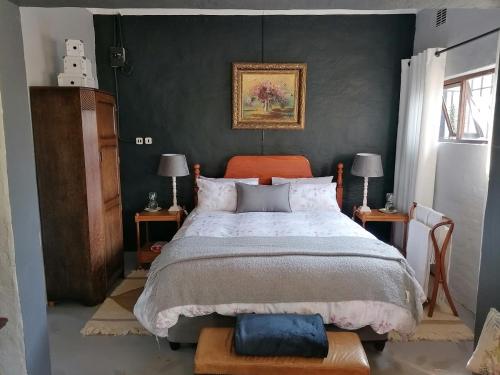 希尔顿Pied Cow Cottage的一间卧室配有一张床和两张带台灯的桌子。