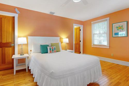 基韦斯特Baya House的卧室设有白色大床和橙色墙壁