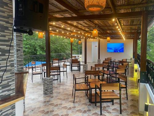 圣玛尔塔AKUAIPPA HOSTAL RESTAURANT的餐厅设有木桌、椅子和屏幕