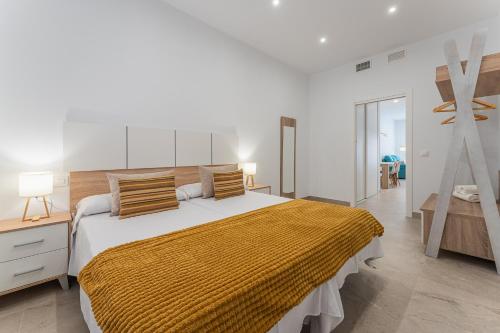 梅里达CMDreams Platinium- Apartamentos turísticos en el centro de Mérida的一间卧室配有一张带黄色毯子的大床