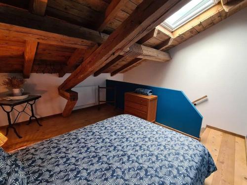 圣迪耶Ancien séchoir du 19ème siècle的一间卧室配有一张蓝色的床和一张桌子
