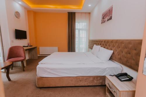 巴库Madinah Hotel的一间卧室配有一张床、一张书桌和一台电视