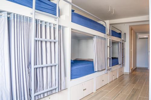 圣安德烈斯Dreamer Beach Club的一间客房配有4张双层床,铺有蓝色床单