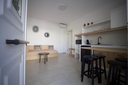 斯基罗斯岛Kotinos Luxury Suites的厨房以及带床和凳子的客厅。