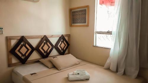 马瑙斯卡萨希尔托精品酒店的一间小卧室,配有一张带窗户的床