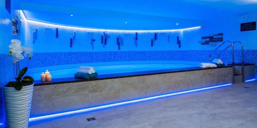 布拉迪斯拉发WX Hotel的带浴缸和蓝色灯光的大浴室