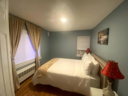 波士顿Cozy Boston Getaway Apartment的卧室配有白色的床和窗户。