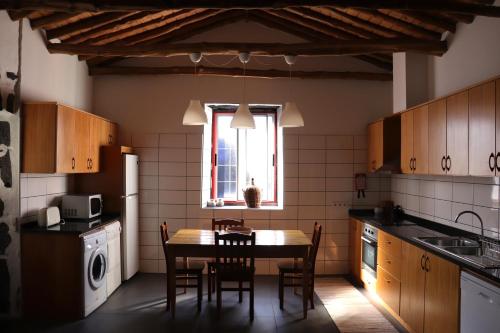 ArcosAdega do Xelica - Holiday Cottage的厨房配有桌椅和窗户。