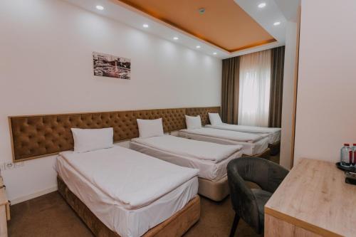 巴库Madinah Hotel的酒店客房,设有四张床和椅子