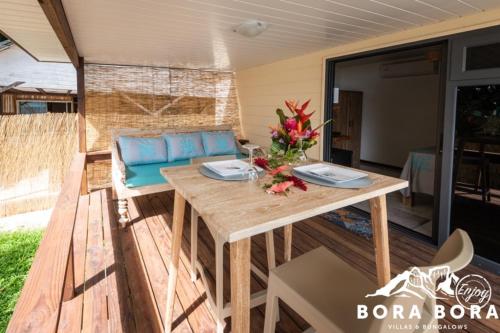 波拉波拉Matira Beach Raitea 2的庭院配有木桌和沙发。