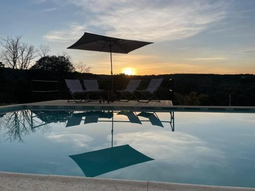 维尼艾什Quinta da Devesa -B2的一个带椅子和遮阳伞的游泳池,并可欣赏日落美景