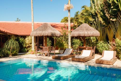 弗洛里亚诺波利斯Casa Mar Campeche的一个带椅子和遮阳伞的游泳池的度假酒店