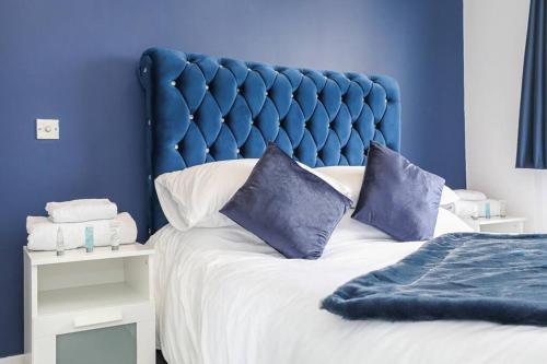 BishopbriggsDoralan的一张带蓝色床头板的床和两个枕头