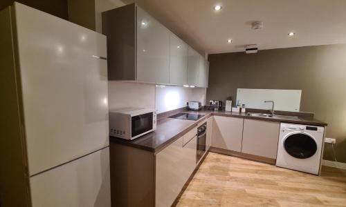 卡迪夫Modern One Bedroom Apartment in Cardiff Bay的厨房配有微波炉、冰箱和水槽